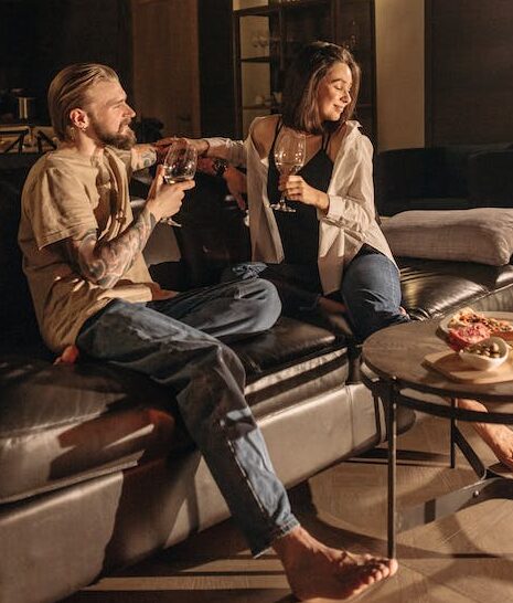 man and woman drinking wine on a sofa